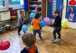 Dzieci bawią się w sali balonami.